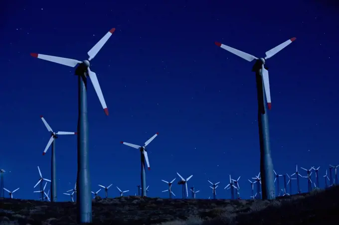 Wind turbines in landscape at night