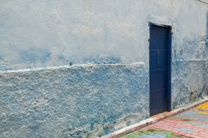 Africa, Morocco, Colorful blue walls and old door in alleyway in medina