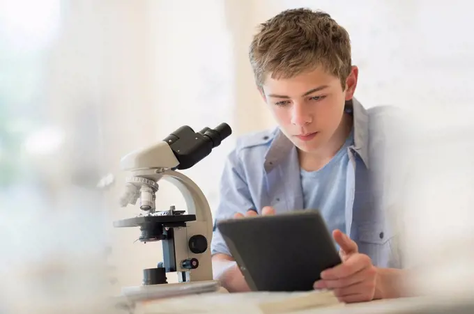 Teenage boy (16-17) using digital tablet in laboratory