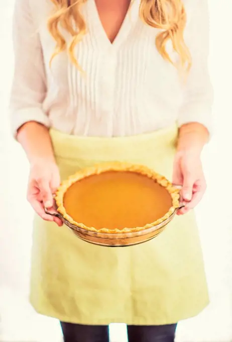 Woman holding pumpkin pie