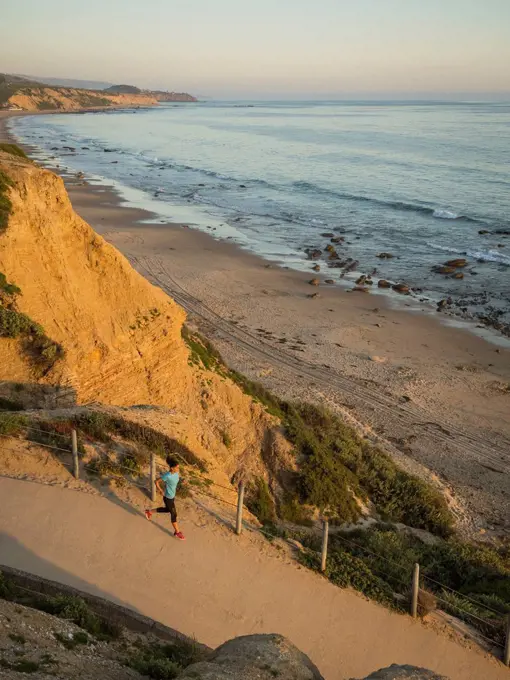 USA, California, Newport Beach, Woman running along footpath