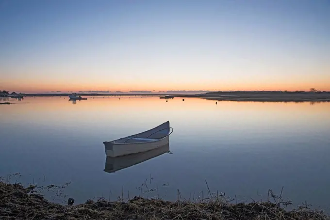 USA, Massachusetts, Cape Cod, Chatham, Boat reflecting in water at dawn