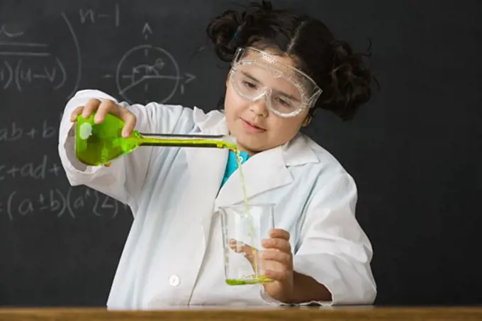 Girl pouring liquid in science class