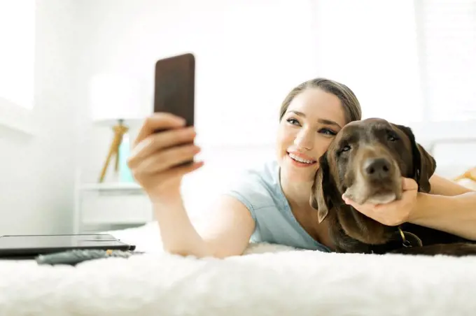 Young woman taking selfie with pet dog