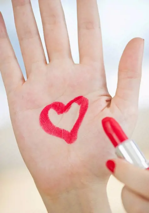 Red heart drawn on hand with lipstick