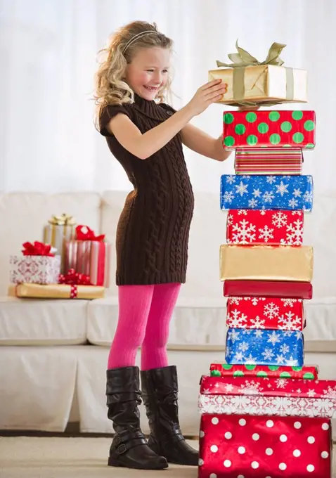 Young girl stacking Christmas gifts