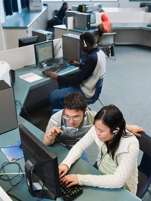 Adult students working on computers at a learning center