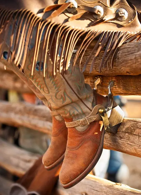 Cowboy boots on fence
