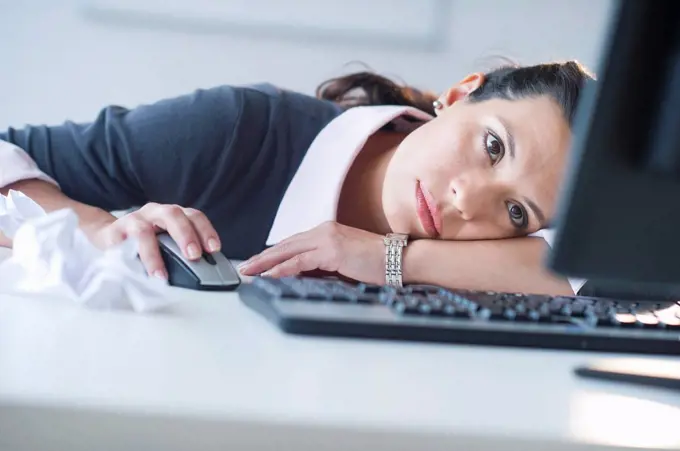 Businesswoman in front of computer, looking tired