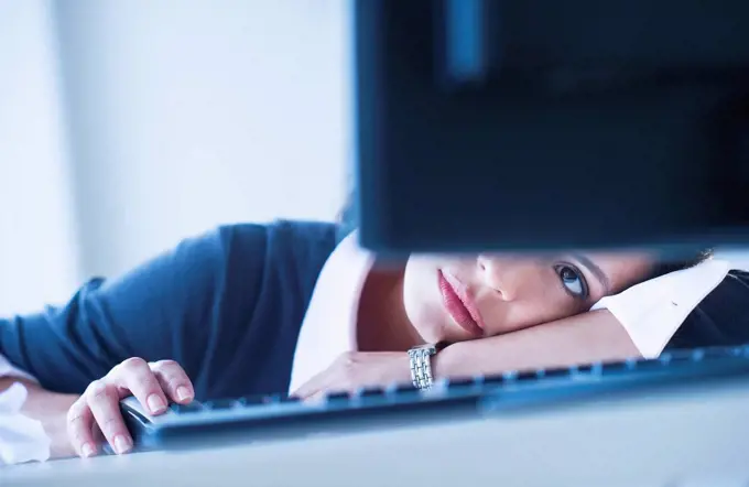 Businesswoman looking tired in front of computer