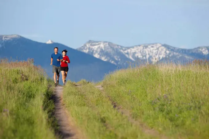USA, Montana, Kalispell, Couple jogging in mountainside