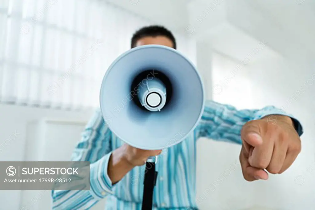 Businessman shouting into a megaphone in an office