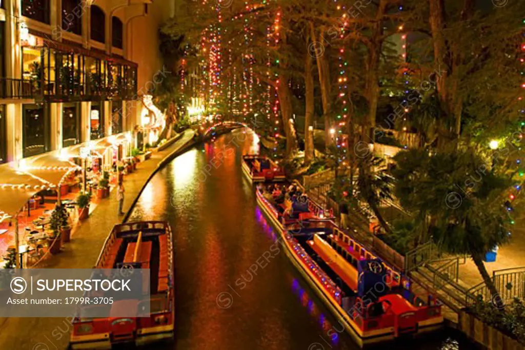 Building lit up at night at the riverside, River Walk, San Antonio, Texas, USA