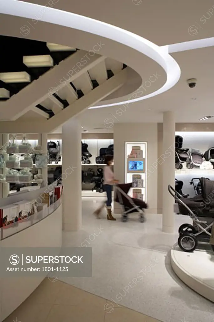 MAMAS AND PAPAS STORE, REGENT STREET, LONDON, W1 OXFORD STREET, UNITED KINGDOM, GROUND FLOOR AREA SHOWING UNDERSIDE OF THE MAIN STAIRS WITH WOMAN PUSHING PRAM BLURRED IN THE BACKGROUND., FOUR IV DESIGN