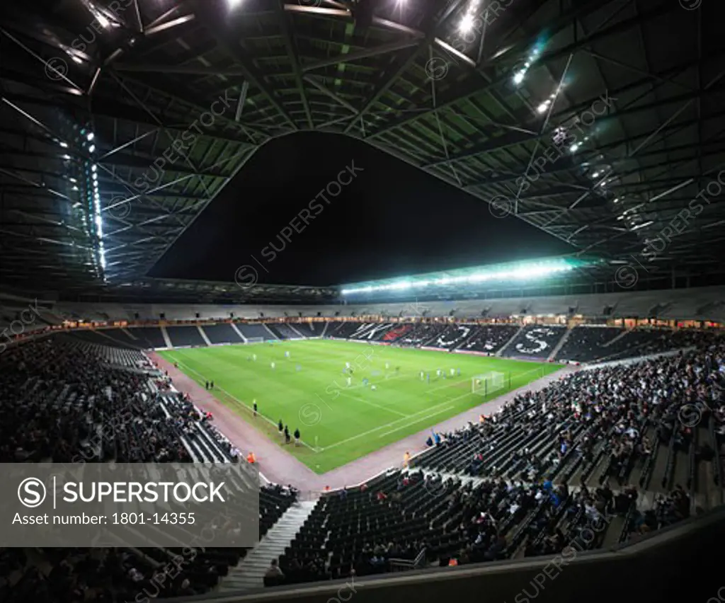 MK DONS STADIUM, MILTON KEYNES, BUCKINGHAMSHIRE, UNITED KINGDOM, EXTERIORS INSIDE AND OUT OF THIS NEW 20, 000 SEATER STADIUM FOR MK DONS UBERSTEIGAN AT NIGHT WITH GAME GOING ON, HOK SPORT