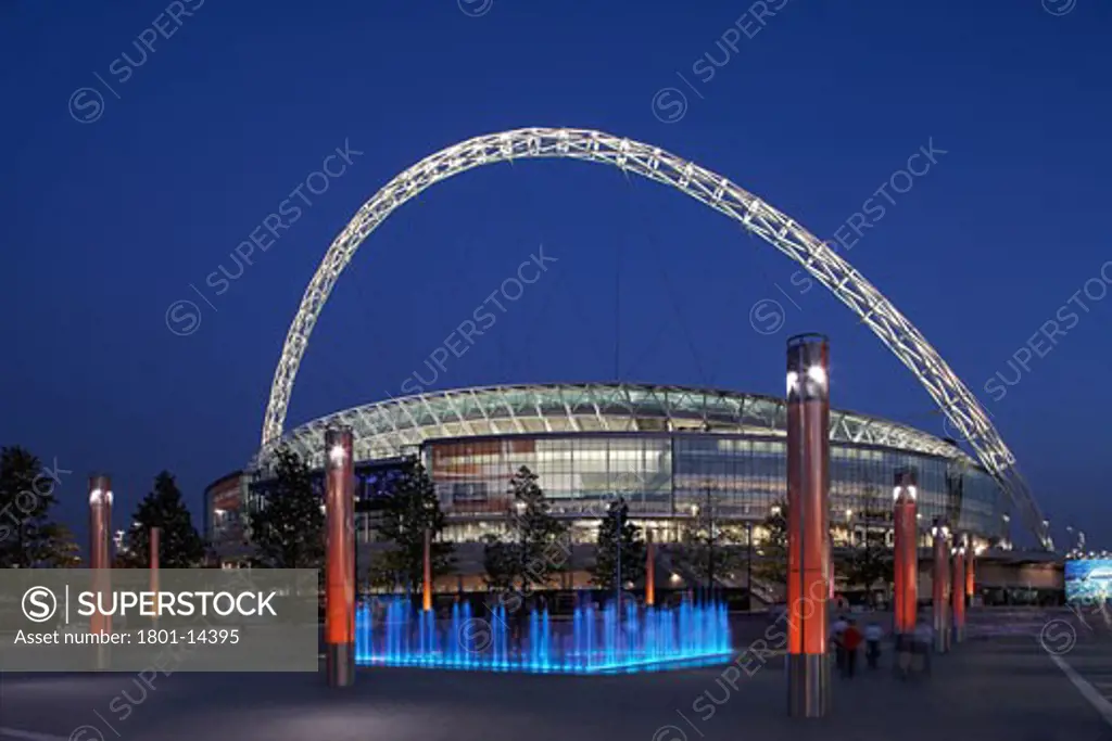 WEMBLEY STADIUM, LONDON, UNITED KINGDOM, NIGHT SHOT WITH BLUE FOUNTAIN IN FOREGROUND, HOK SPORT | FOSTER AND PARTNERS