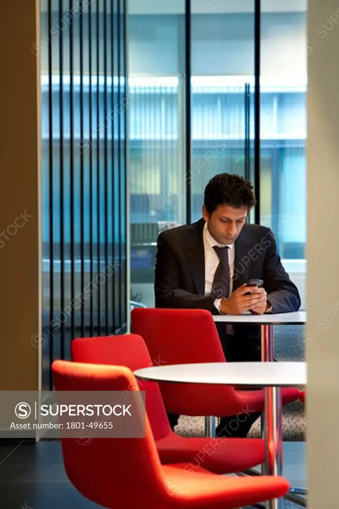 Orrick, London, United Kingdom, Tp Bennett, ORRICK HERRINGTON & SUTCLIFFE TP BENNETT LONDON UK 2009. INTERIOR SHOT SHOWING MAN USING A PHONE AT A TABLE IN A PARTITIONED MEETING AREA