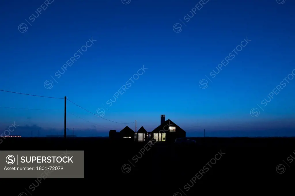 Shingle House, Dungeness, United Kingdom. Architect Nord Architecture, 2011. Front elevation at dusk.