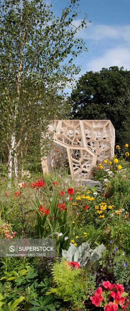 Times Eureka Pavilion, Kew, United Kingdom. Architect NEX, 2011. Panoramic exterior looking over flower beds and framed by silver birches.