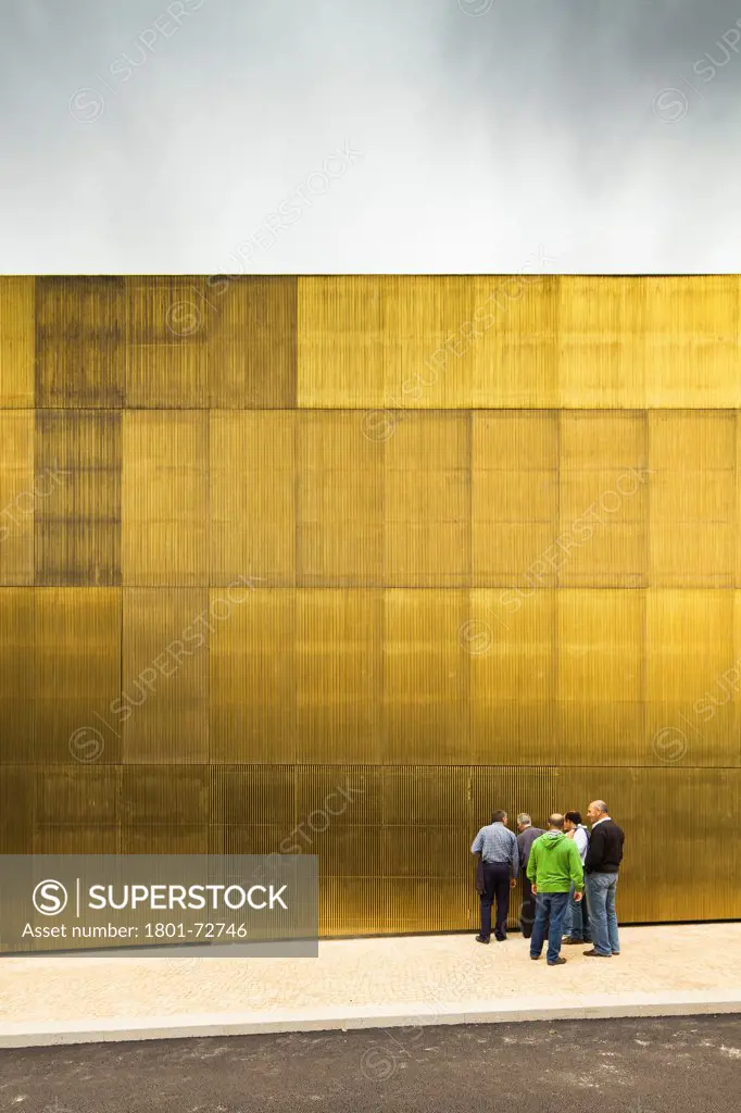 Platform for Arts and Creativity, Guimaraes, Portugal. Architect Pitágoras Arquitectos, 2012. Golden facade from street.