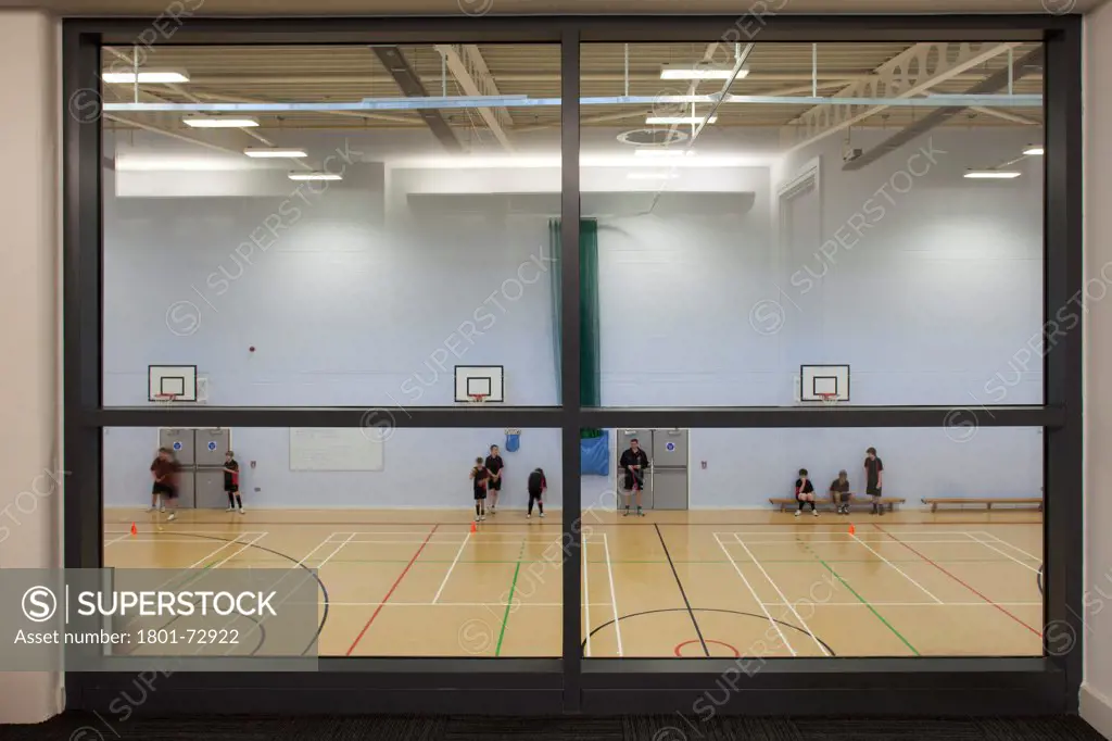 Trinity School Sports Hall, Newbury, United Kingdom. Architect ADP Architects Ltd, 2012. Interior view of main sports hall through viewing area window.