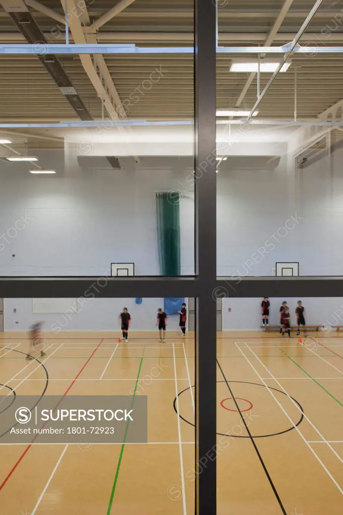 Trinity School Sports Hall, Newbury, United Kingdom. Architect ADP Architects Ltd, 2012. Interior view of main sports hall through viewing area window.