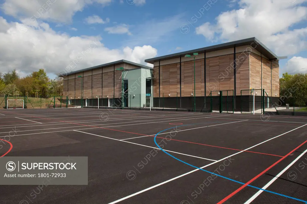 Trinity School Sports Hall, Newbury, United Kingdom. Architect ADP Architects Ltd, 2012. Exterior view across all weather sports pitch to south facade of sports hall.