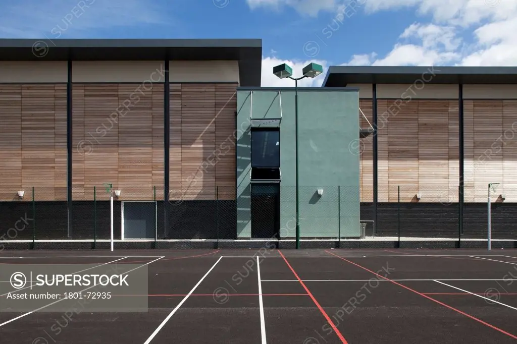 Trinity School Sports Hall, Newbury, United Kingdom. Architect ADP Architects Ltd, 2012. View across all weather sports pitch of sports hall south elevation,.