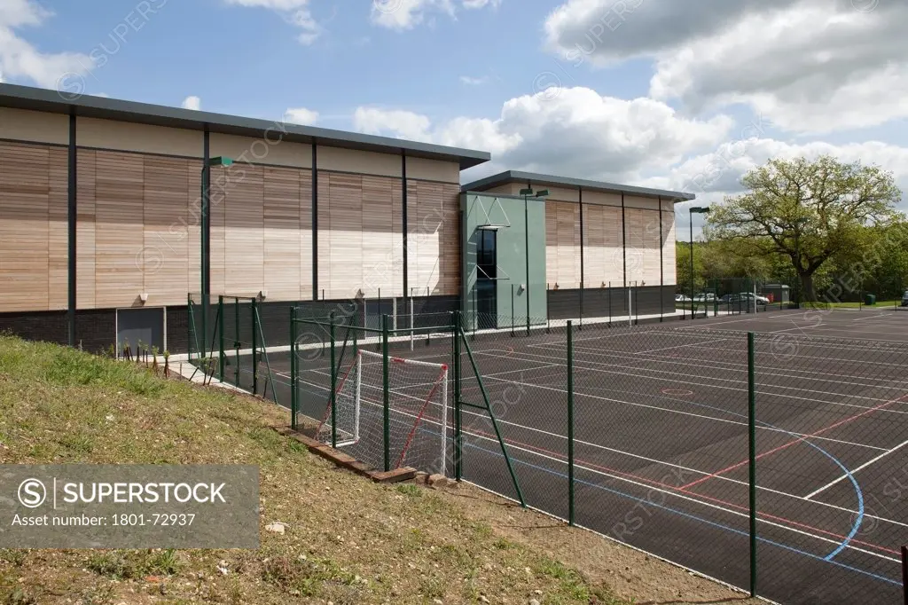 Trinity School Sports Hall, Newbury, United Kingdom. Architect ADP Architects Ltd, 2012. View across all weather sports pitch of sports hall south elevation.
