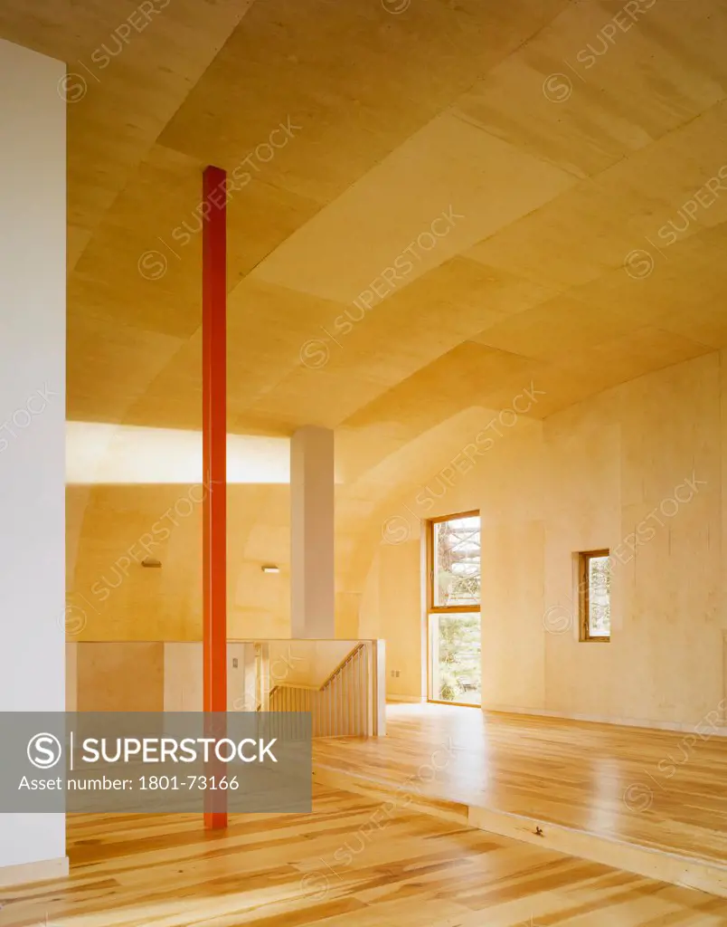 Ballynoe, Dublin, Ireland. Architect McCullough Mulvin, 2006. View of living space showing stairs, supporting column and birch plywood lined floor and ceiling.