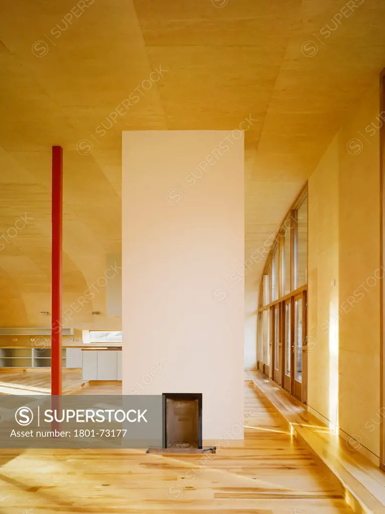 Ballynoe, Dublin, Ireland. Architect McCullough Mulvin, 2006. View of living space showing supporting column, chimney, birch plywood lined floor and ceiling and doors to balcony.