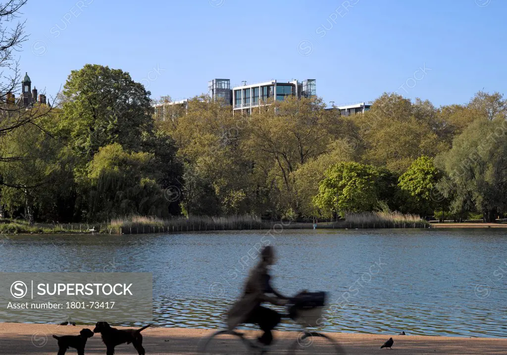 One Hyde Park, Luxury Flats, Europe, United Kingdom,2011, Rogers Stirk Harbour + Partners. Overall exterior view over Serpentine with passing figure on bike.