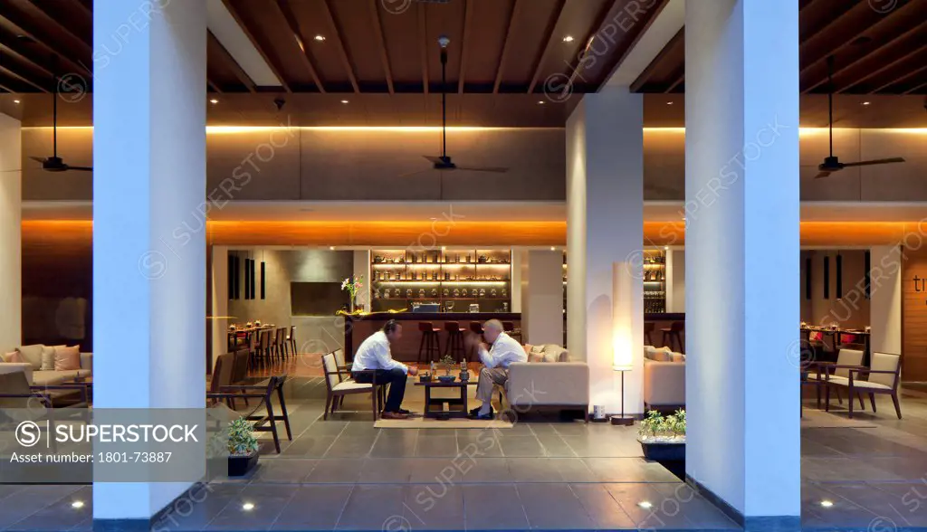 Alila Bangalore Hotel and Apartments, Office Apartments Hotel, Asia, India,2012, Allies and Morrison, Hundred Hands. Dusk view of the lounge and bar area with two people in discussion.