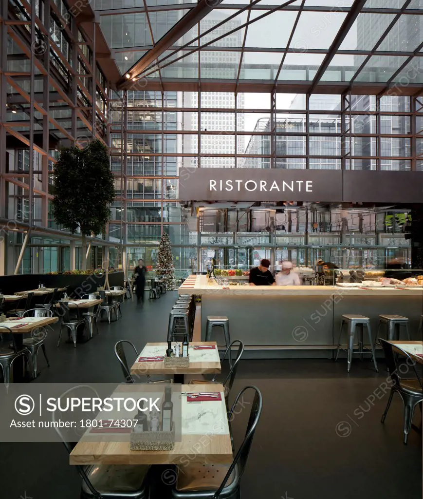 Obika Canary Wharf, London, United Kingdom. Architect: Labics, 2012. Interior of restaurant with staff in kitchen area and signage.