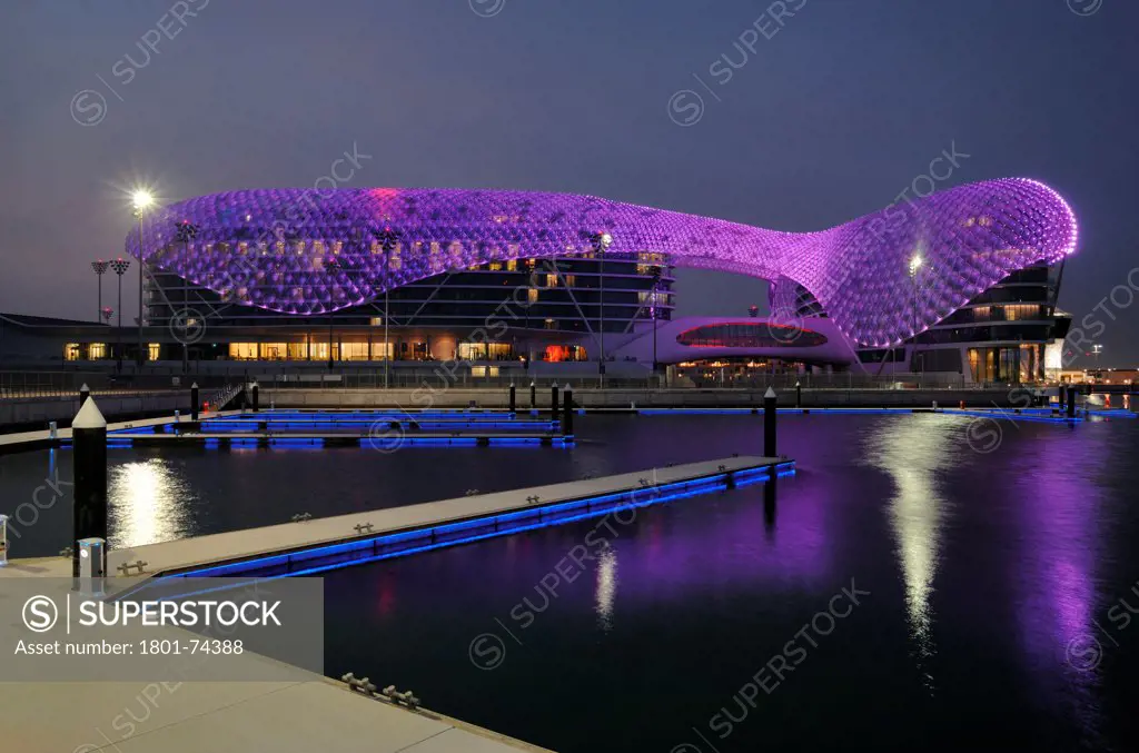 Yas Hotel, Abu Dhabi, United Arab Emirates. Architect: Asymptote, Hani Rashid, Lise Anne Couture, 2010. General view from Marina with purple LED skin.