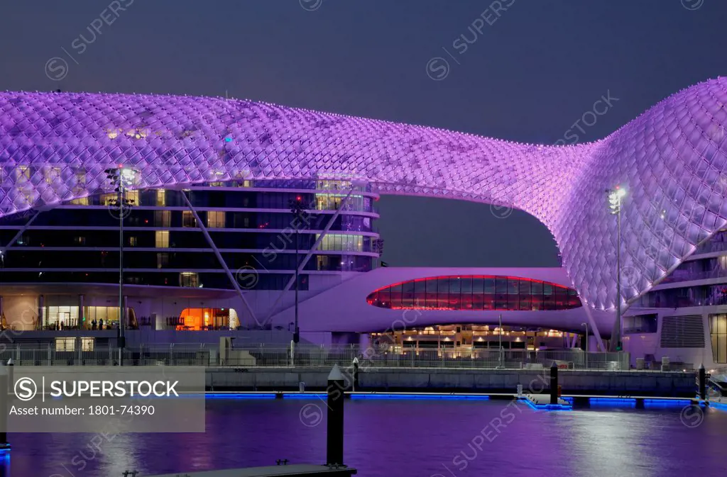 Yas Hotel, Abu Dhabi, United Arab Emirates. Architect: Asymptote, Hani Rashid, Lise Anne Couture, 2010. General view from Marina with purple LED skin.