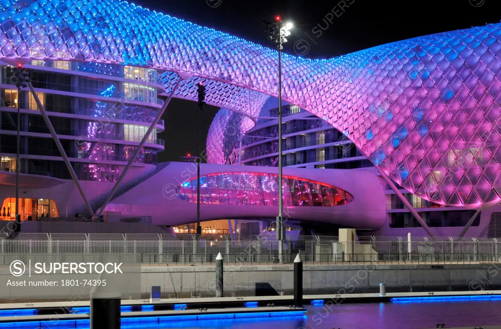 Yas Hotel, Abu Dhabi, United Arab Emirates. Architect: Asymptote, Hani Rashid, Lise Anne Couture, 2010. General view from Marina with blue and purple LED skin.