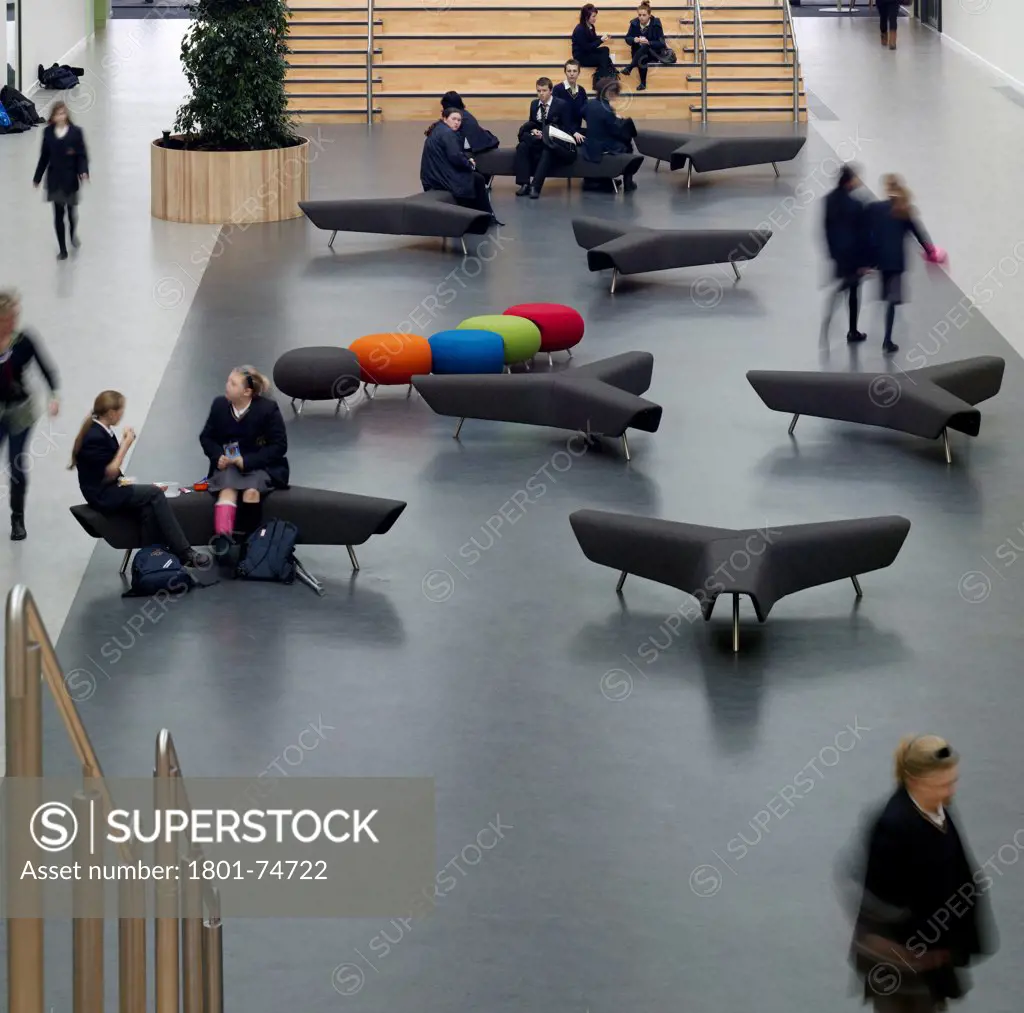 Stanley Park High School, Sutton, United Kingdom. Architect: Haverstock Associates LLP, 2011. Close-up of informal seating in atrium with students.