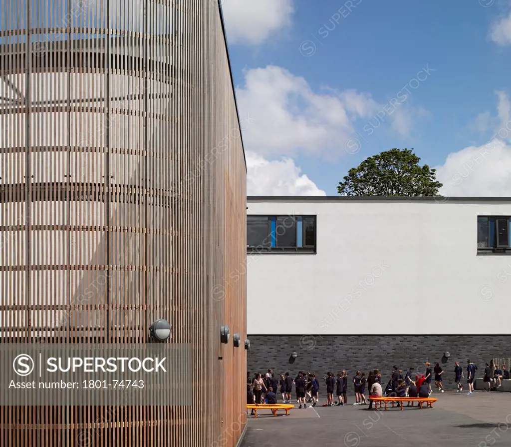 Stanley Park High School, Sutton, United Kingdom. Architect: Haverstock Associates LLP, 2011. Partial view of timber cladding and schoolyard.