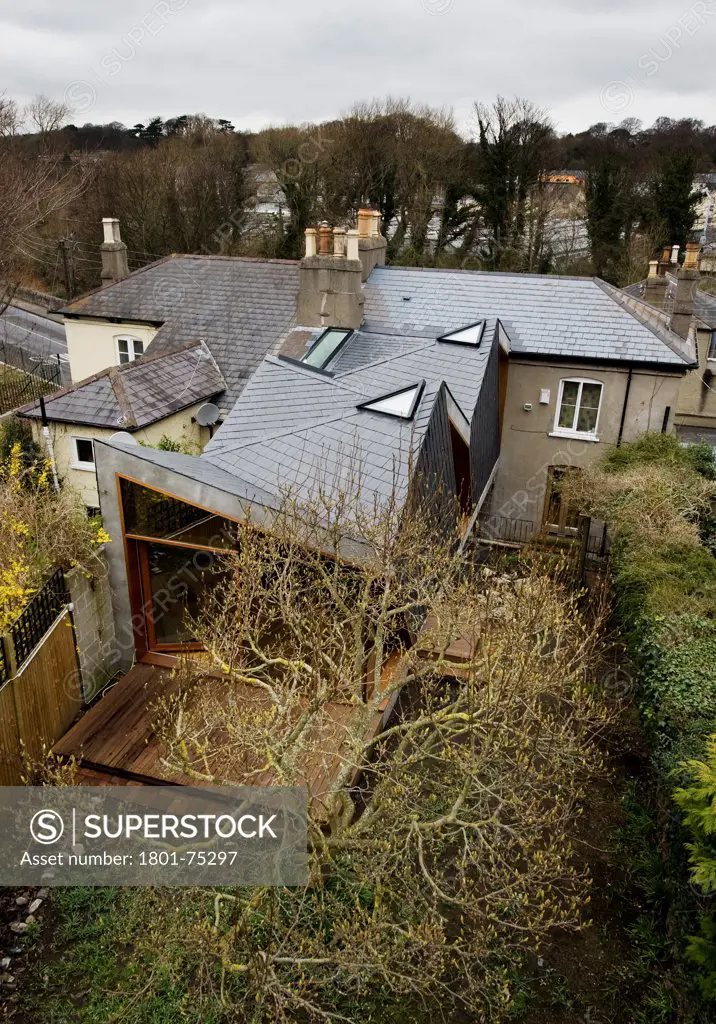 Slate Storey Extension, Dublin, Ireland. Architect: Tom Maher, 2008. View of extension showing angled slate roof, roof lights, patio and tree.