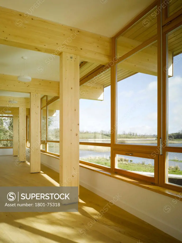 Ballybay Wetland Centre, Ballybay, Ireland. Architect: Solearth Ecological Architecture, 2008. View of interior showing timber supports that extend to exterior, timber framed windows and view to exterior.