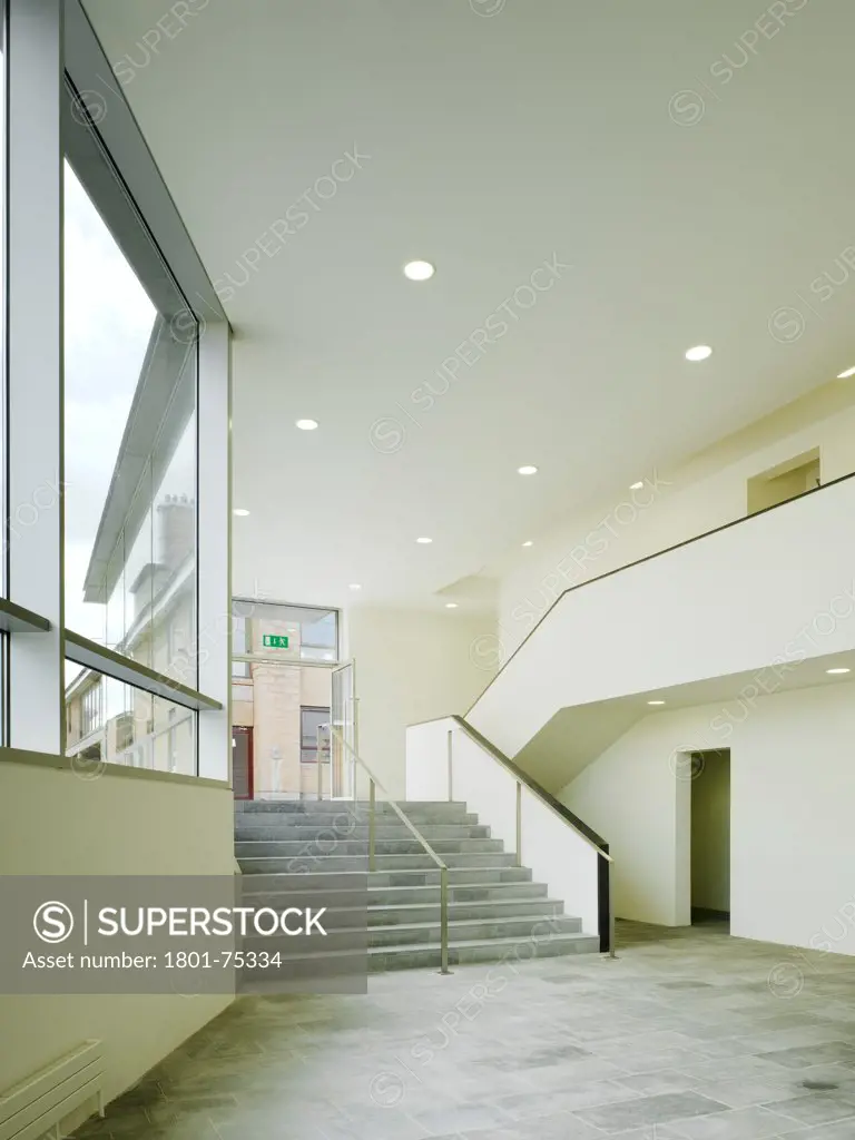 Sandford Park School, Ranelagh, Ireland. Architect: DTA Architects, 2007. View of entrance to multipurpose hall showing stairs, flooring and artificial lighting.