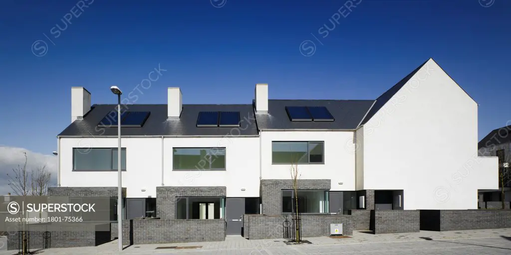 Gleann Bhan, Galway, Ireland. Architect: DTA Architects, 2008. View of houses from road showing front elevations and side elevation.