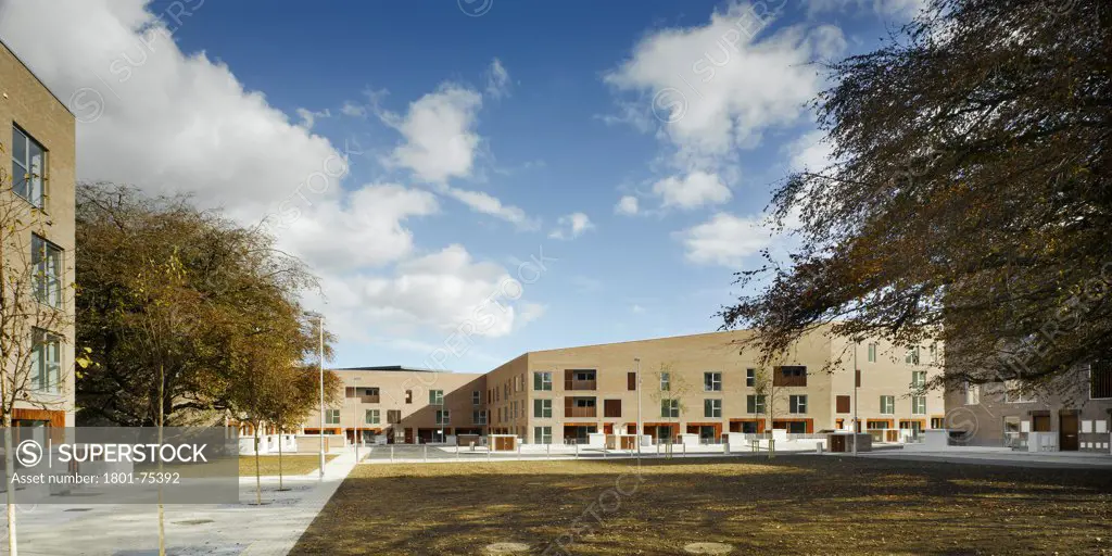 Santry Demesne, Fingal, Ireland. Architect: DTA Architects, 2009. View of development from landscaped green space showing path and brick housing blocks with timber cladding.