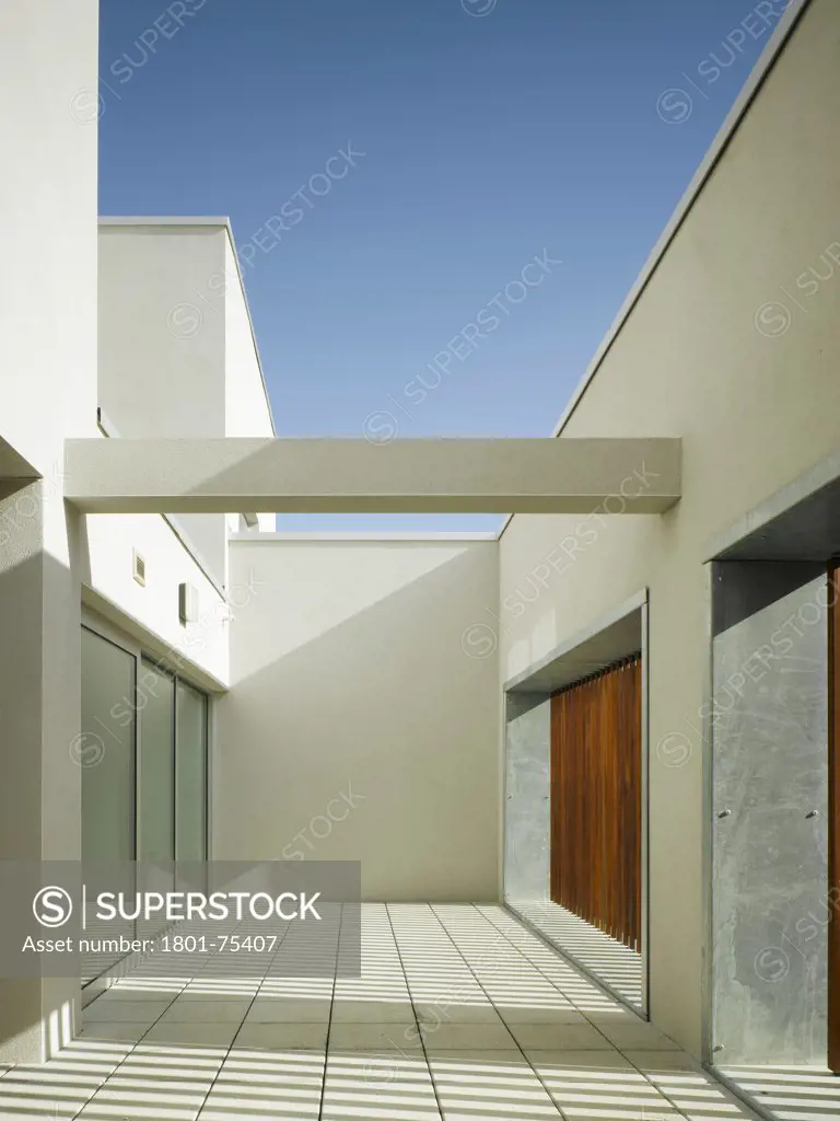 Santry Demesne, Fingal, Ireland. Architect: DTA Architects, 2009. View of roof terrace showing light through timber slats, concrete finishing, structural beam and sliding doors.