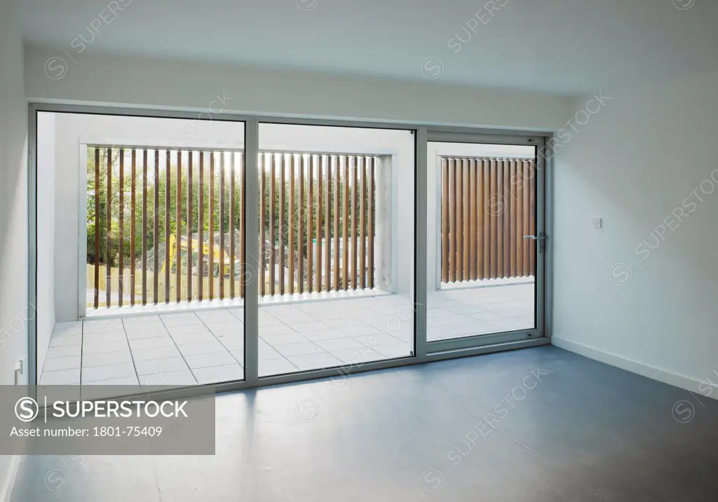 Santry Demesne, Fingal, Ireland. Architect: DTA Architects, 2009. View from living space showing view through sliding door to roof terrace with timber slats and concrete finishing.