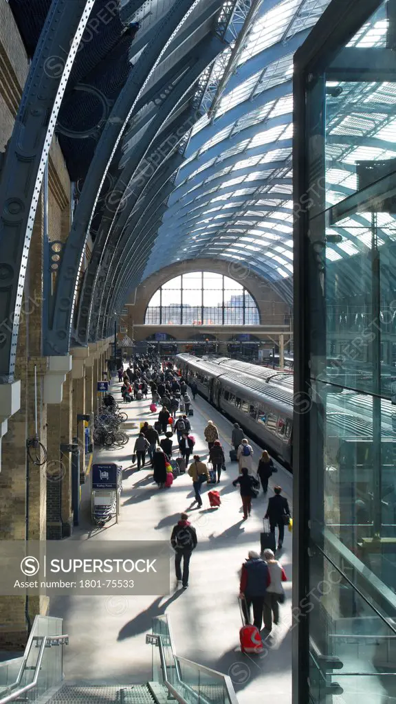 King's Cross Station, Railway Station, Europe, United Kingdom, , 2012, John McAslan & Partners. View from walkway to station platform with passengers.