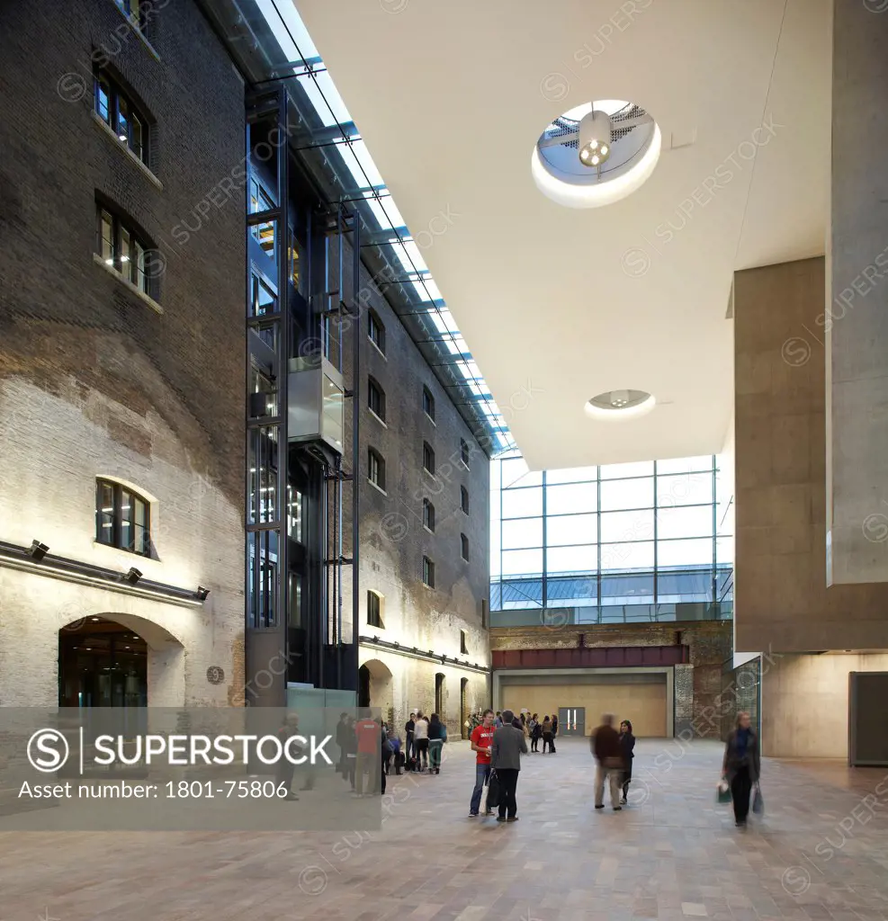 Central Saint Martins, London, United Kingdom. Architect: Stanton Williams, 2011. Atrium with people.