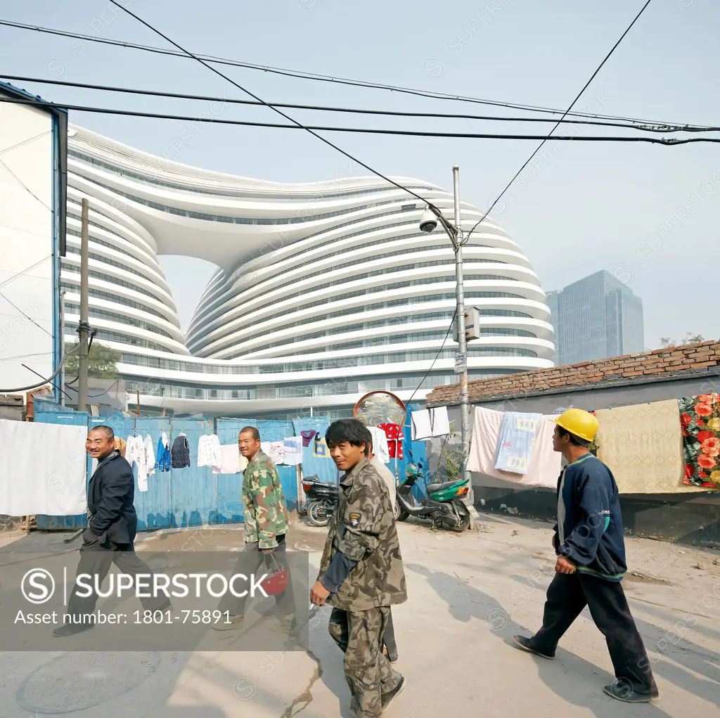 Galaxy Soho, Beijing, China. Architect: Zaha Hadid Architects, 2012. Urbane street scene with construction workers.