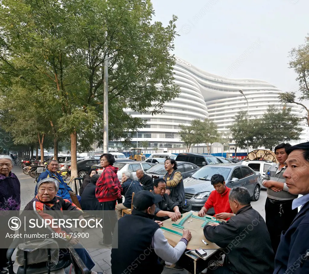 Galaxy Soho, Beijing, China. Architect: Zaha Hadid Architects, 2012. Authentic street scene with modern complex in background.